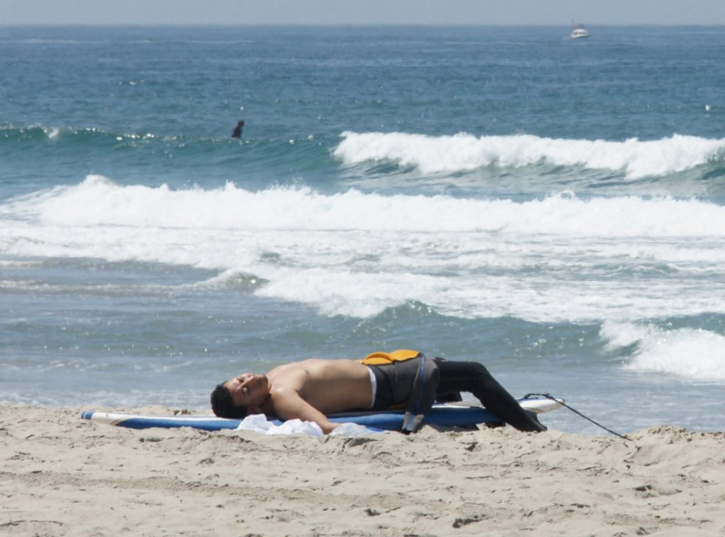 Sleep on your surfboard on the sand.