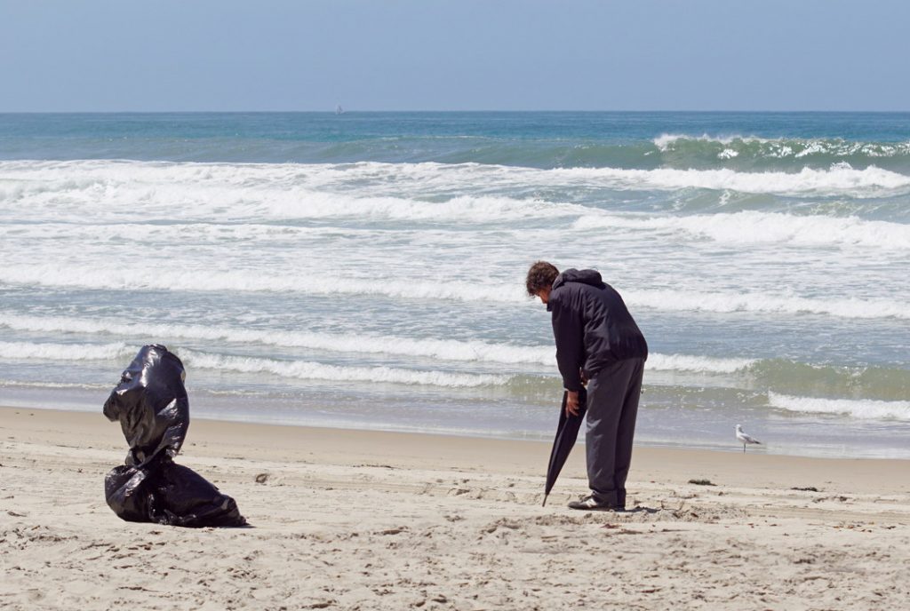 Write messages in the sand with an umbrella.