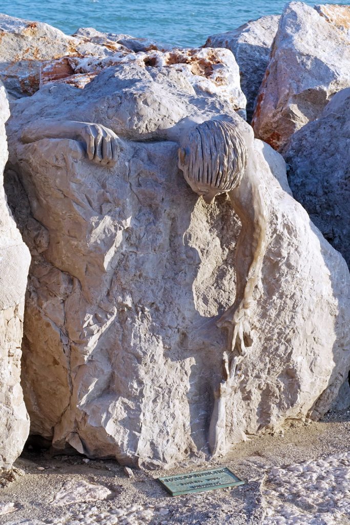 A man crawling over a ledge.