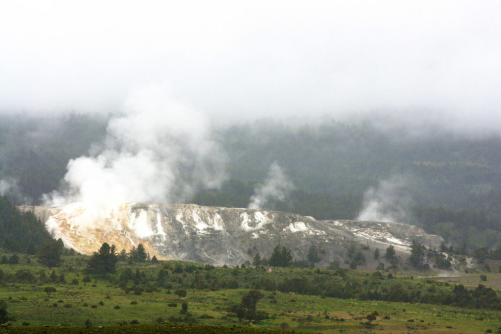 Mist, smelling of sulfur, rises above the hills on a cool spring day.