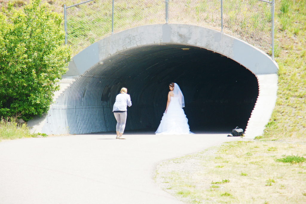 A bride poses in a pedestrian tunnel.