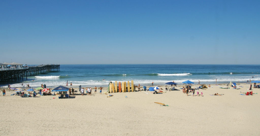 Longboarders preparing to surf near Crystal Pier.