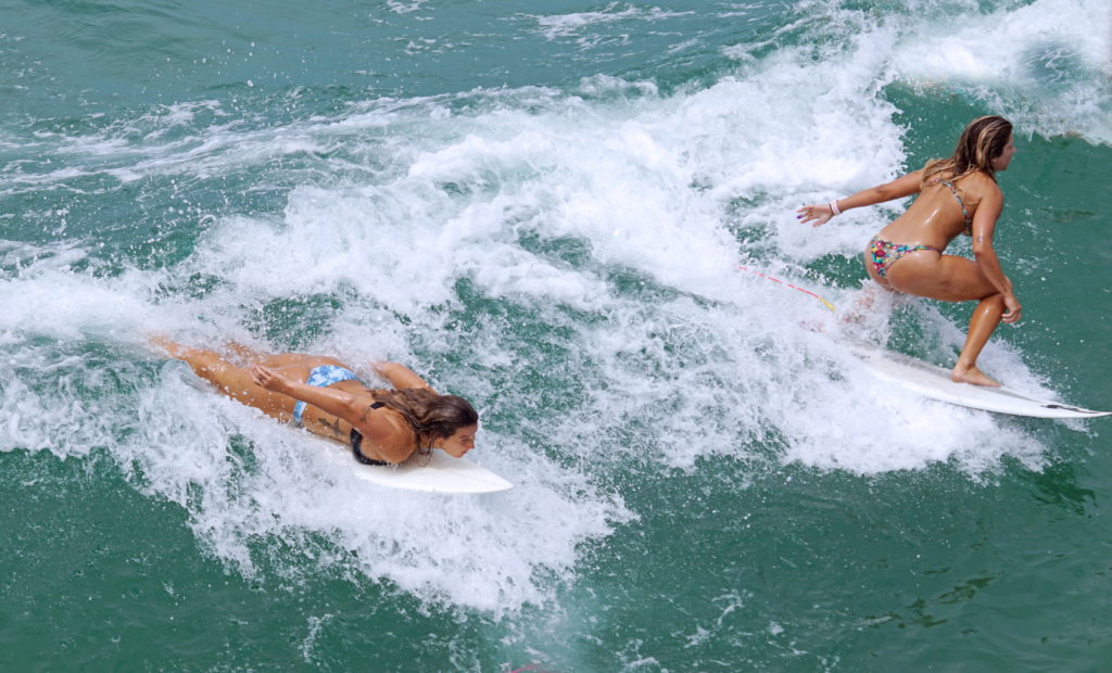 These surfers are demonstrating two different styles.