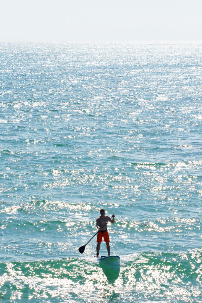 Paddleboarders play in the surf, too.