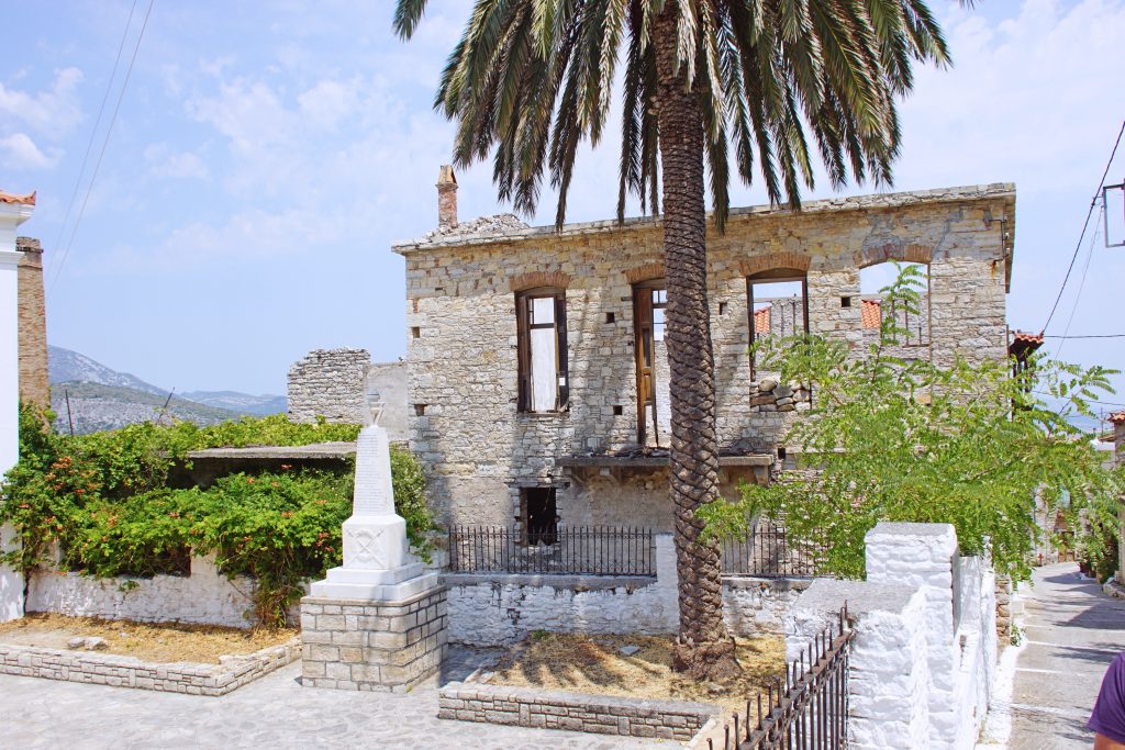 A small monument in the town square near ruins.