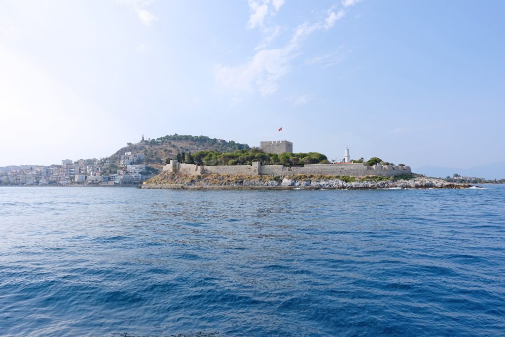 Güvercinada as seen from the ferry, with Kuşadası in the background.