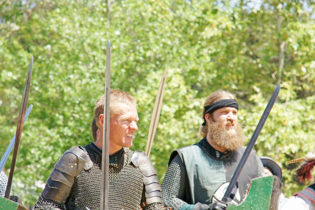 Knights clad in maille and iron glare at enemy forces.