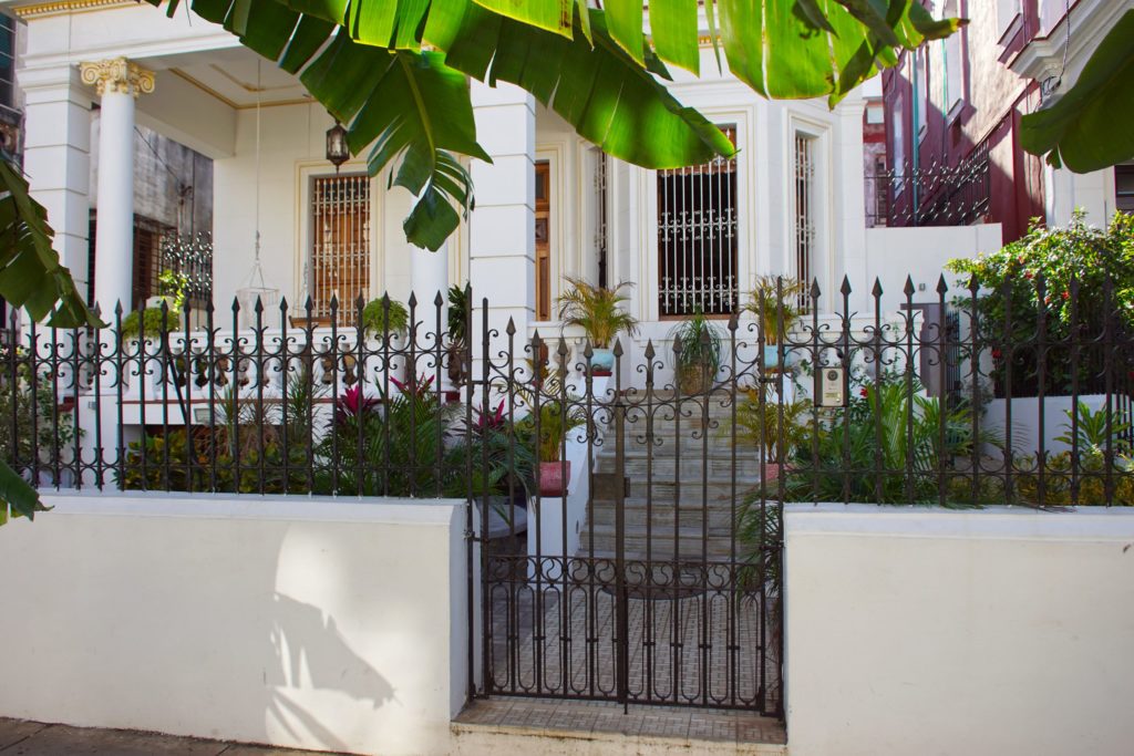 A well-kept front porch behind a menacing fence.